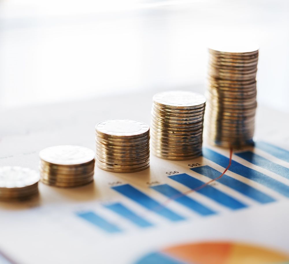 Stack of coins on top of some data graphics