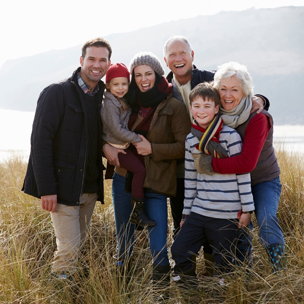 Intergenerational family smiling at a camera