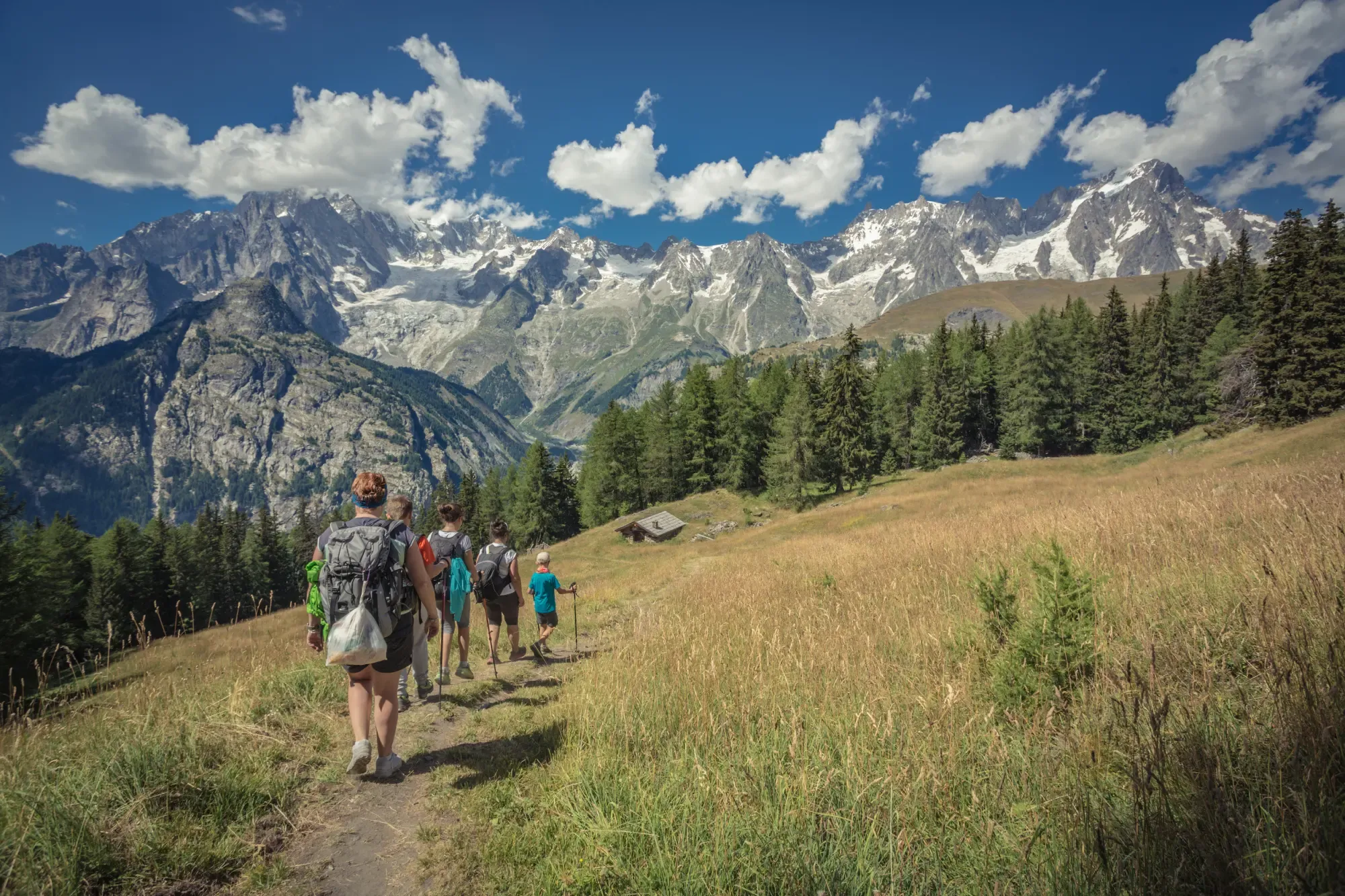 Group of People with backpacks walking on a mountain path
